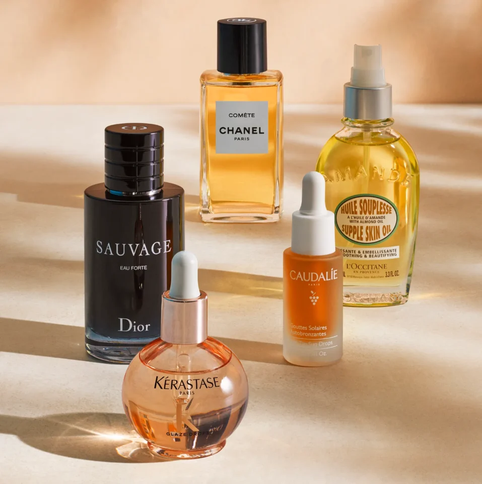 Selection of 2025 award-winning beauty products including Chanel Comète, Dior Sauvage Eau Forte, L'Occitane Supple Skin Oil, Caudalie Tan Sun Drops, and Kérastase Glaze Drops.